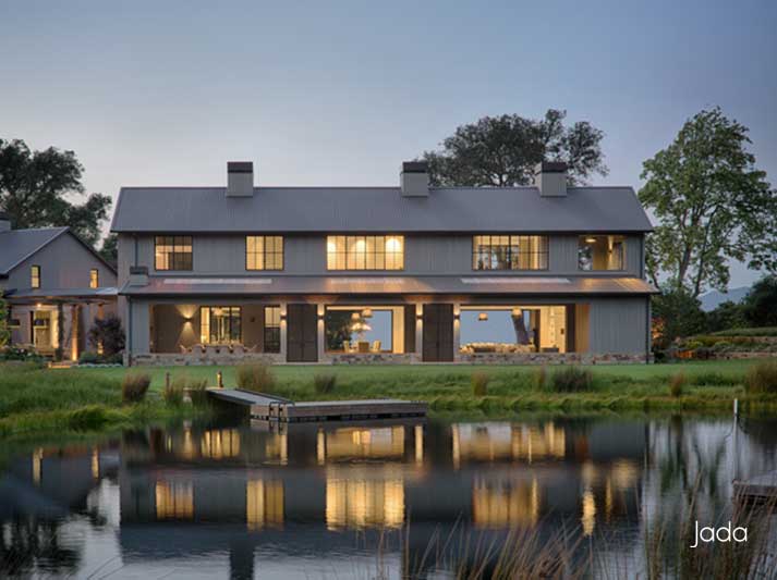 Exterior view of home by lake with steel windows and doors. Discover 5 ways to improve indoor air quality through healthy building design.